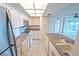 Bright kitchen has white cabinets and stainless-steel appliances with an opening to the living room at 240 Sand Key Estates Dr # 243, Clearwater Beach, FL 33767