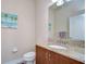 Bathroom features a granite vanity top, undermount sink, framed mirror, and palm tree artwork at 2566 Lake Manor Dr, Land O Lakes, FL 34639