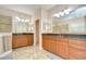 Bright bathroom featuring double vanities with granite countertops and wooden cabinets at 2566 Lake Manor Dr, Land O Lakes, FL 34639