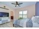 Bedroom with ceiling fan, large window, and attached bathroom at 2566 Lake Manor Dr, Land O Lakes, FL 34639