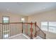 Hallway with an elegant wrought iron railing staircase, light vinyl floors, and an abundance of natural light at 2566 Lake Manor Dr, Land O Lakes, FL 34639
