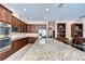 Spacious open-concept kitchen with stainless steel appliances, an island with bar stool seating, and granite countertops at 2566 Lake Manor Dr, Land O Lakes, FL 34639
