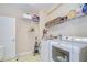 Well-equipped laundry room featuring a washer, dryer, and shelving for storage at 2566 Lake Manor Dr, Land O Lakes, FL 34639