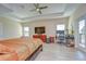 Main bedroom featuring a ceiling fan, accent wall, tv, desk, and outside access to the pool at 2566 Lake Manor Dr, Land O Lakes, FL 34639