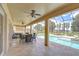 Covered patio with ample seating and a view of the pool and the lake at 2566 Lake Manor Dr, Land O Lakes, FL 34639