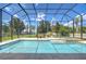 A stunning screened-in pool with adjacent spa and manicured lawn that leads to a serene lake at 2566 Lake Manor Dr, Land O Lakes, FL 34639