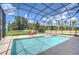 Stunning pool with enclosed screen, manicured lawn, and lake views at 2566 Lake Manor Dr, Land O Lakes, FL 34639