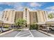 Multi-story condo building featuring balconies, palm trees, and covered parking at 2621 Cove Cay Dr # 302, Clearwater, FL 33760
