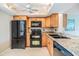 A kitchen featuring wooden cabinets, granite countertops, and black appliances at 2621 Cove Cay Dr # 302, Clearwater, FL 33760