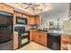 Open kitchen with wooden cabinets, granite countertops, and black appliances at 2621 Cove Cay Dr # 302, Clearwater, FL 33760