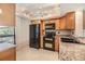 Bright kitchen with wooden cabinets, granite countertops, and modern black appliances at 2621 Cove Cay Dr # 302, Clearwater, FL 33760