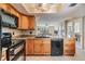 A kitchen featuring wooden cabinets, granite countertops, and an island overlooking the living area at 2621 Cove Cay Dr # 302, Clearwater, FL 33760