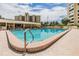 Enjoy a refreshing swim in the outdoor pool with comfortable lounge seating and community building views at 2621 Cove Cay Dr # 302, Clearwater, FL 33760