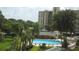 Elevated view of a gorgeous community pool surrounded by lush landscaping and lounge chairs at 2621 Cove Cay Dr # 302, Clearwater, FL 33760