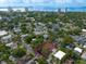 Aerial view of a home in a lush, green neighborhood with a city skyline and bay in the distance at 2900 W Estrella St, Tampa, FL 33629