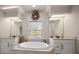 Spa-like bathroom featuring a large soaking tub, double vanities, and decorative wreath at 2900 W Estrella St, Tampa, FL 33629