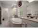 Bright bathroom featuring double sinks, soaking tub, and natural light at 2900 W Estrella St, Tampa, FL 33629