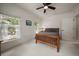 Sunlit bedroom with wooden bed frame, side table, large window, and neutral decor at 2900 W Estrella St, Tampa, FL 33629