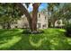 Elegant home exterior featuring a lush green lawn and mature trees providing shade and curb appeal at 2900 W Estrella St, Tampa, FL 33629