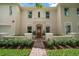 Close up of arched front entry with balcony, tan stucco, red tile roof, and brick walkway at 2900 W Estrella St, Tampa, FL 33629