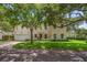 Two-story home with tan stucco, red tile roof, arched entry and brick driveway with mature landscaping at 2900 W Estrella St, Tampa, FL 33629