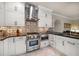 Kitchen featuring stainless appliances, Wolf range, black countertops, and tile backsplash at 2900 W Estrella St, Tampa, FL 33629