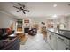 Open concept living room with kitchen, fireplace, leather furniture, and ceiling fan at 2900 W Estrella St, Tampa, FL 33629