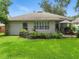 Well-manicured backyard with a charming garden, a cozy patio area with an umbrella, and lush green grass at 3101 Beaver Pond Trl, Valrico, FL 33596