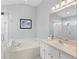 Bright bathroom with a soaking tub, a separate glass-enclosed shower, and a vanity with ample counter space at 3101 Beaver Pond Trl, Valrico, FL 33596