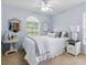 Cozy bedroom featuring a comfortable bed, ample natural light, and stylish hexagonal mirrors at 3101 Beaver Pond Trl, Valrico, FL 33596