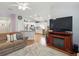 Open concept living room and kitchen with hardwood floors and a large television at 3101 Beaver Pond Trl, Valrico, FL 33596
