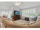 Bright living room with a fireplace and plantation shutters, opening to the dining area at 3101 Beaver Pond Trl, Valrico, FL 33596