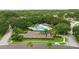 Aerial view of a community pool area with a pool, parking, palm trees and green landscaping at 3101 Beaver Pond Trl, Valrico, FL 33596