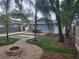 Landscaped backyard featuring artificial turf, a fire pit, and a wooden deck, creating an inviting outdoor space at 318 W Crest Ave, Tampa, FL 33603