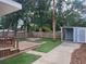 Backyard view from wood deck with a putting green, shed, fire pit, and mature trees at 318 W Crest Ave, Tampa, FL 33603