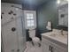 Bathroom featuring a tiled shower, hexagon tile floor, and dark green accent wall at 318 W Crest Ave, Tampa, FL 33603