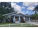Charming single-story home with a cute picket fence, well-manicured lawn, and inviting front porch at 318 W Crest Ave, Tampa, FL 33603