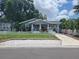 Charming single-story home featuring a cute picket fence and a covered carport on a sunny day at 318 W Crest Ave, Tampa, FL 33603
