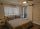Bedroom with neutral tones, sheer curtains, and an en-suite bathroom sliding door at 318 W Crest Ave, Tampa, FL 33603