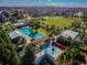 Aerial view showcasing a community pool, splashpad, green space, and surrounding homes at 3257 Heart Pine Ave, Odessa, FL 33556