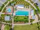 Birds eye view of a well-designed community pool, splashpad, and lush landscaping at 3257 Heart Pine Ave, Odessa, FL 33556