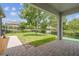 A view of the backyard, featuring a lawn, mature trees, and a paved patio area at 3257 Heart Pine Ave, Odessa, FL 33556
