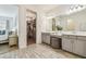 Bathroom with double vanity, a tufted stool, a walk-in closet, and wood-look tile floors at 3257 Heart Pine Ave, Odessa, FL 33556