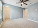 Spacious bedroom with neutral carpet, modern ceiling fan, and ample closet space at 3257 Heart Pine Ave, Odessa, FL 33556