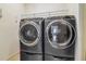 Laundry room showing a modern washer and dryer set, and a wire rack shelf at 3257 Heart Pine Ave, Odessa, FL 33556