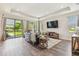 Spacious living room with hardwood floors, modern decor, and access to an outdoor patio area at 3257 Heart Pine Ave, Odessa, FL 33556