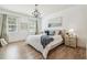 Main bedroom features a chandelier, hardwood floors, and large windows at 3257 Heart Pine Ave, Odessa, FL 33556