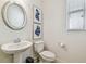 Bright powder room features stylish pedestal sink, decorative mirror, and modern artwork at 3257 Heart Pine Ave, Odessa, FL 33556