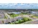 An aerial view showcases homes near a community lake, amenities, and meticulously landscaped areas at 34163 Radley Way, Wesley Chapel, FL 33545