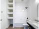 Elegant bathroom featuring white tiles, a shower-tub combo, built-in shelves and a marble countertop vanity at 34163 Radley Way, Wesley Chapel, FL 33545